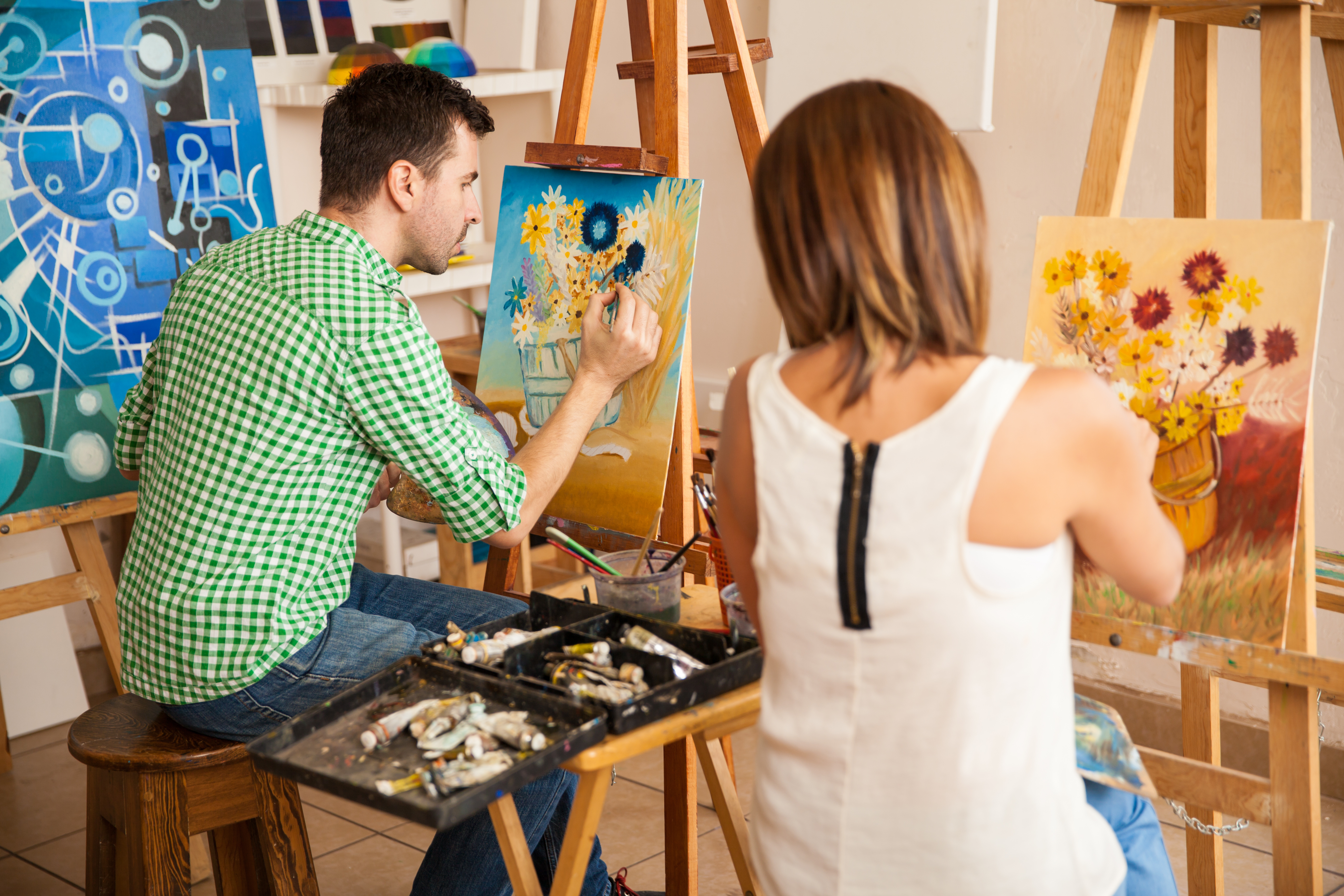 Twee personen verven op canvas